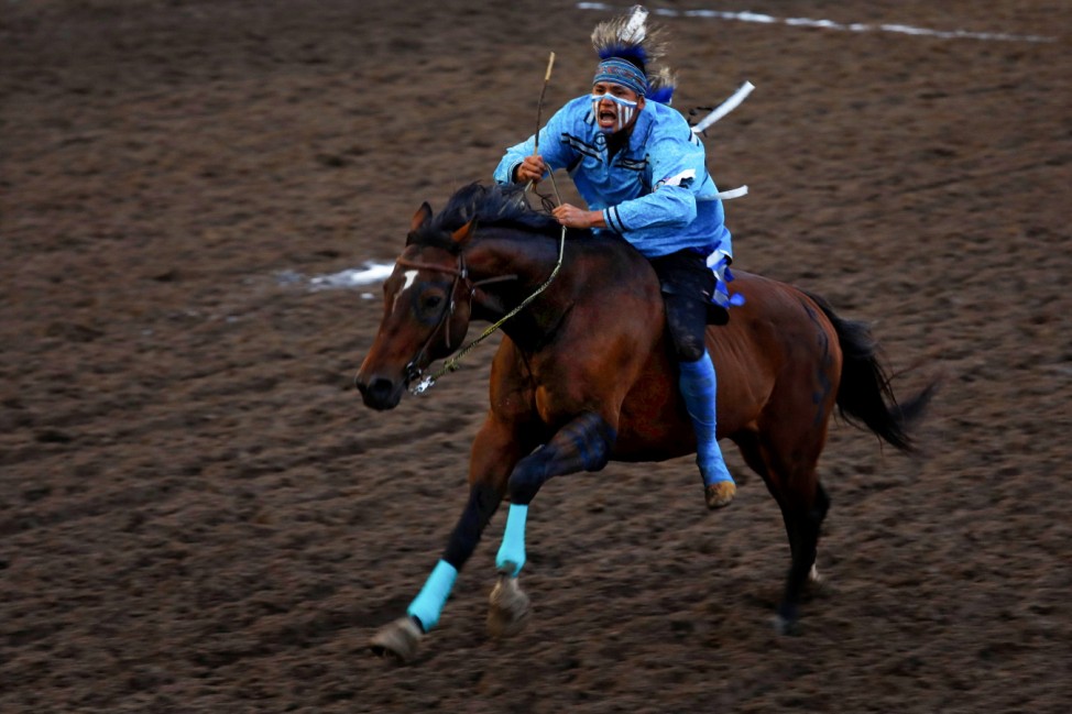Tyler Leather of the Okan North Blackfoots races on his horse during the Indigenous Relay Races at the Calgary Stampede rodeo in Calgary
