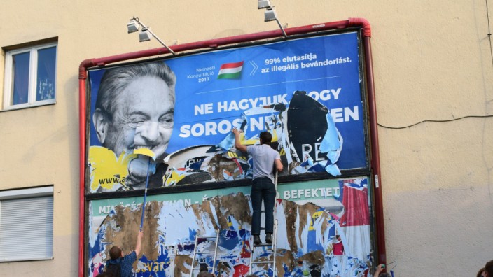 Ungarn: Regierungskritiker reißen in Budapest Plakate mit der Botschaft "Lassen wir es nicht zu, dass Soros am Ende lacht" herunter.