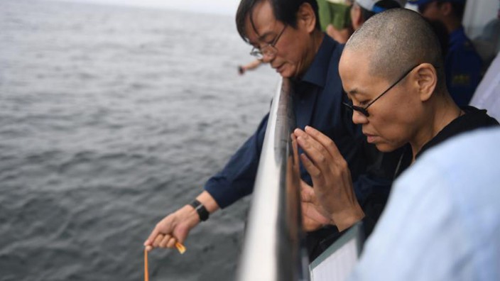Merkel in China: Liu Xia, die Frau des Literatur-Nobelpreisträgers Liu Xiaobo, betet im Juli 2017 bei dessen Seebestattung vor der Küste von Dalian. Sie ist bis heute unter Hausarrest des chinesischen Regimes.