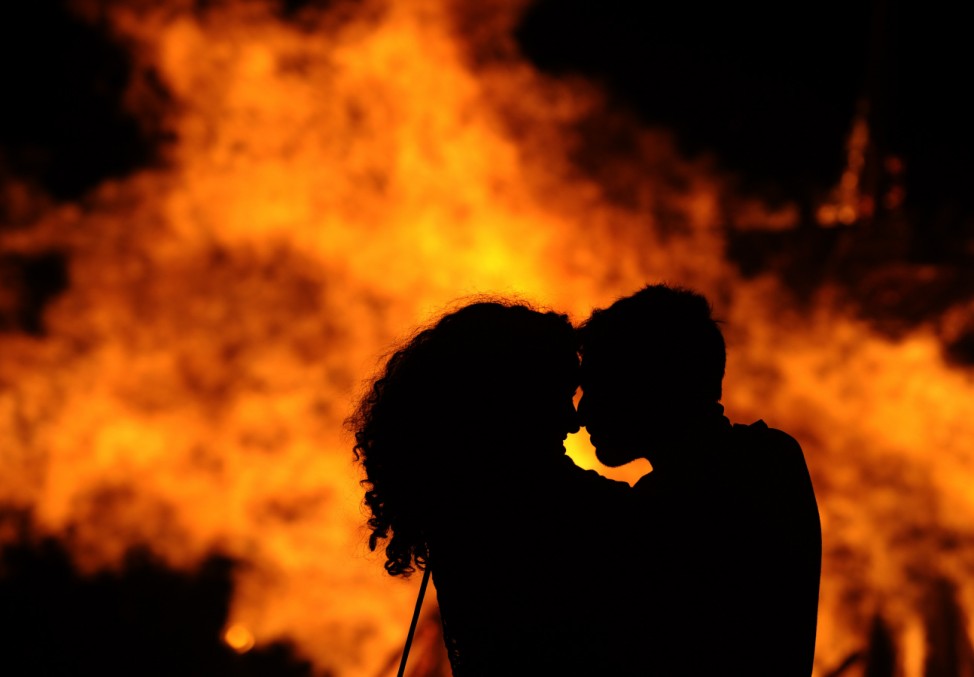 A couple embraces during a party held on the night of the San Juan bonfire on the beach of Playa de Poniente in Gijon