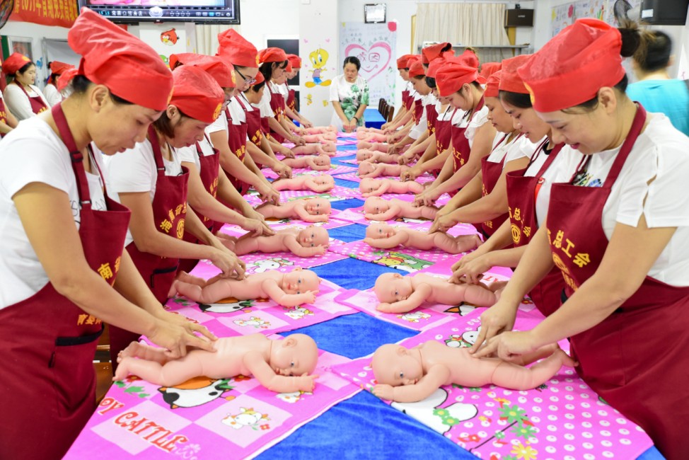 People participate in a free infant care training course organized by local labor union in Haikou