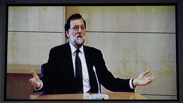 Spain's Prime Minister Mariano Rajoy is seen on a video screen in the press area as he testifies as a witness in the Gurtel corruption trial in San Fernando de Henares