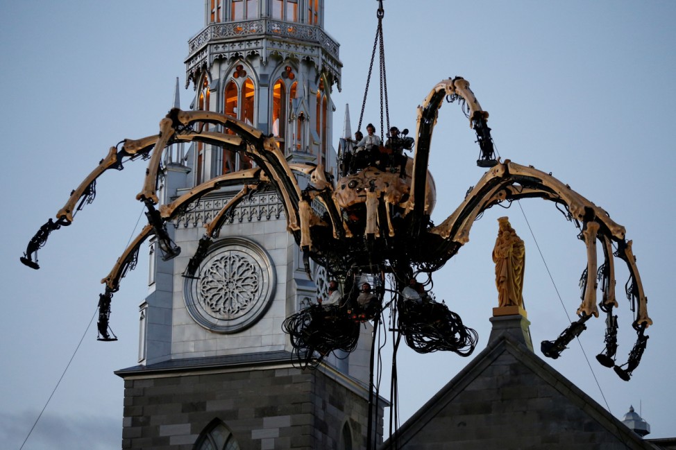 The giant mechanical spider Kumo is lowered in front of the Notre-Dame Cathedral Basilica in Ottawa