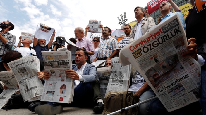 Press freedom activists read opposition newspaper Cumhuriyet during a demonstration in solidarity with the jailed members of the newspaper outside a courthouse, in Istanbul