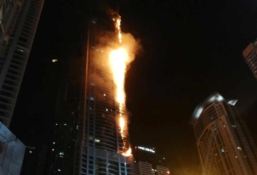 Flames shoot up the sides of the Torch tower residential building in the Marina district, Dubai, United Arab Emirates in this picture by Mitch Williams