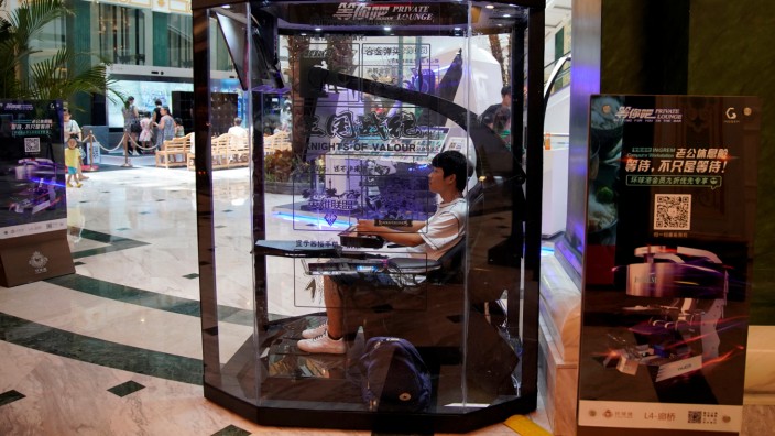 An employee demonstrates a 'husband pod' at a shopping mall in Shanghai