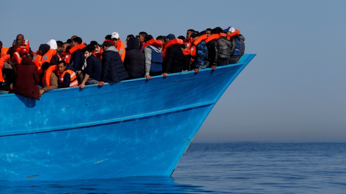 FILE PHOTO: Migrants on a wooden boat await rescue by the Malta-based NGO Migrant Offshore Aid Station (MOAS) in the central Mediterranean