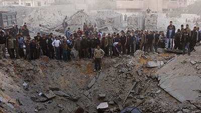 Krieg im Gaza-Streifen: Menschen stehen am Rand eines Kraters: Die Bombe traf das Versteck von Hamas Innenminister Said Siam.