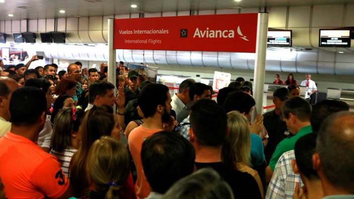 People congregate in front of counters of Avianca airline at the Simon Bolivar airport in Caracas