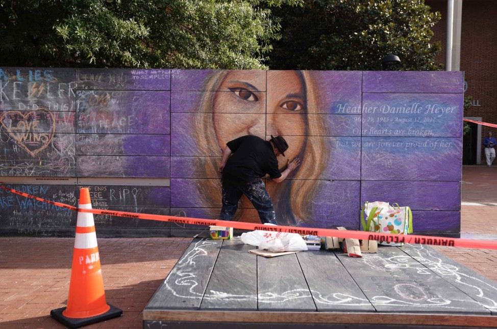 An artist works on a mural of car attack victim Heather Heyer prior to a memorial service for Heyer in Charlottesville, Virginia