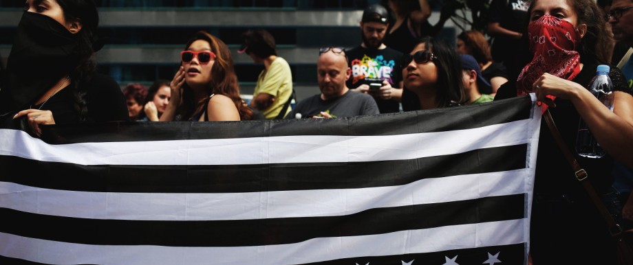Nach Charlottesville: Demonstranten halten eine schwarz getönte US-Flagge als Symbol gegen die gewaltsamen Ausschreitungen in Charlottesville.