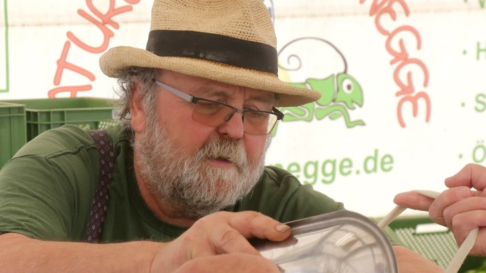 SZ-Serie: Arbeitszeit: In Hosenträgern und mit einem Strohhut auf dem Kopf steht Horst Schönegge an seinem Stand auf dem Freisinger Wochenmarkt.
