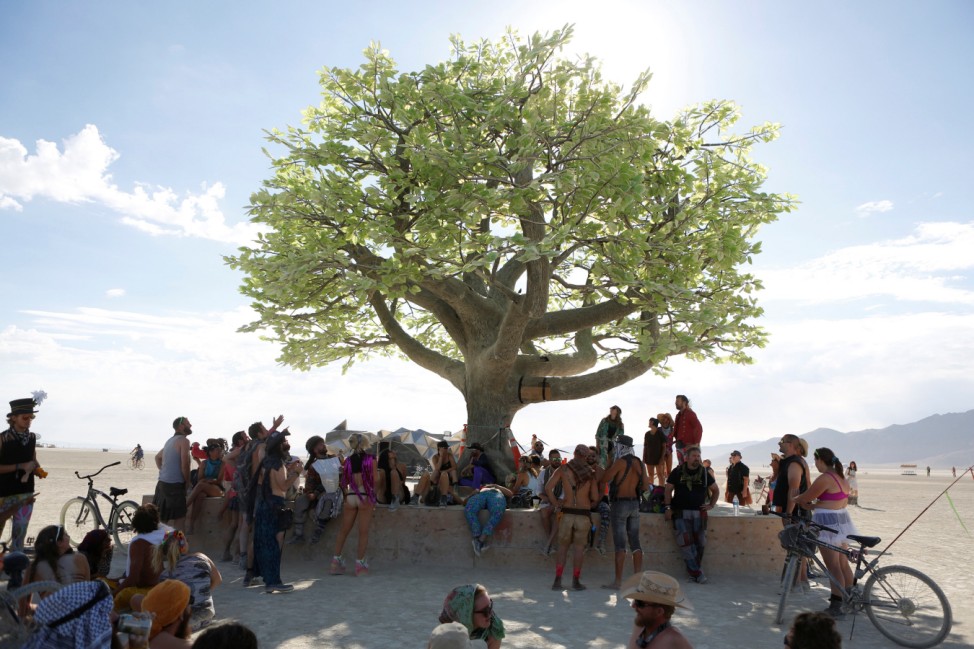 Participants gather in the shade of the art installation Tree of Ténéré as approximately 70,000 people from all over the world gathered for the annual Burning Man arts and music festival in the Black Rock Desert of Nevada