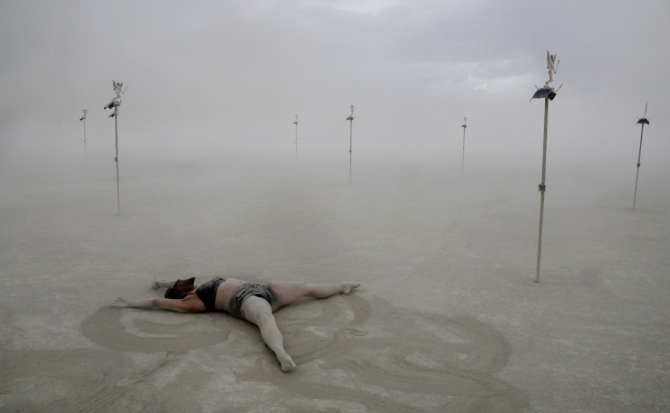 Burning Man participant Kai Rey dances alone in the midst of a desert dust storm at the Burning Man festival in the Black Rock Desert of Nevada