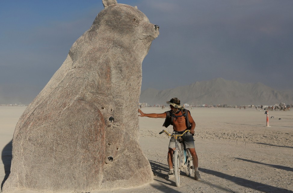 Participant touches the art installation Ursa Mater as approximately 70,000 people from all over the world gathered for the annual Burning Man arts and music festival in the Black Rock Desert of Nevada