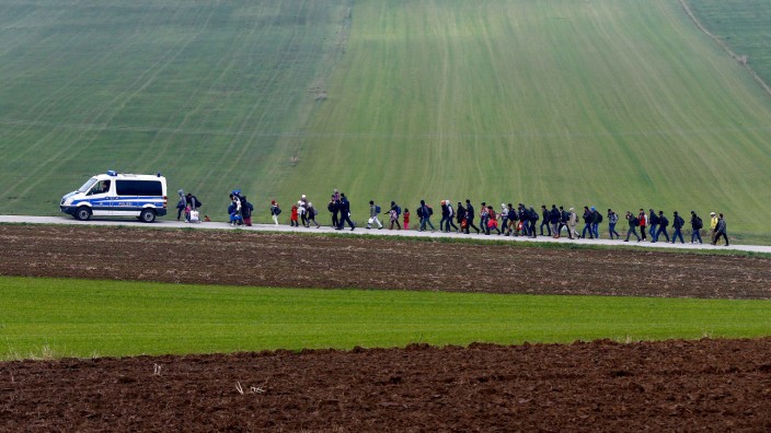 Migrants are escorted by German police after crossing the Austrian-German border in Wegscheid