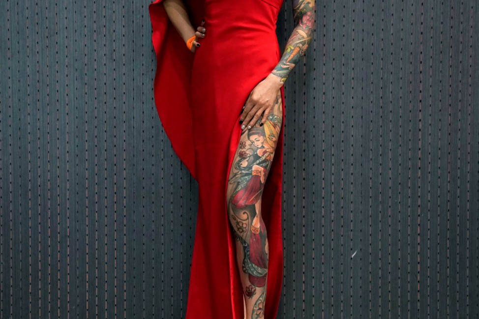 A woman poses with her tattoo during the Shanghai Tattoo Extreme & Body Art Expo 2017 in Shanghai