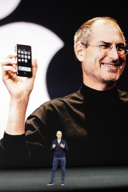 Apple: Ten years after: Apple-Chef Tim Cook präsentiert am Dienstag in der Zentrale in Cupertino das neue iPhone X. Hinter ihm ein großes Foto von Apple-Gründer Steve Jobs, wie er vor zehn Jahren das erste iPhone vorstellt.