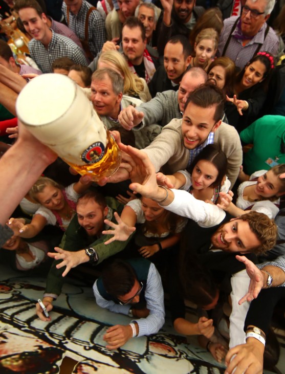 Visitors reach for the first mugs of beer during the opening day of the 184th Oktoberfest in Munich