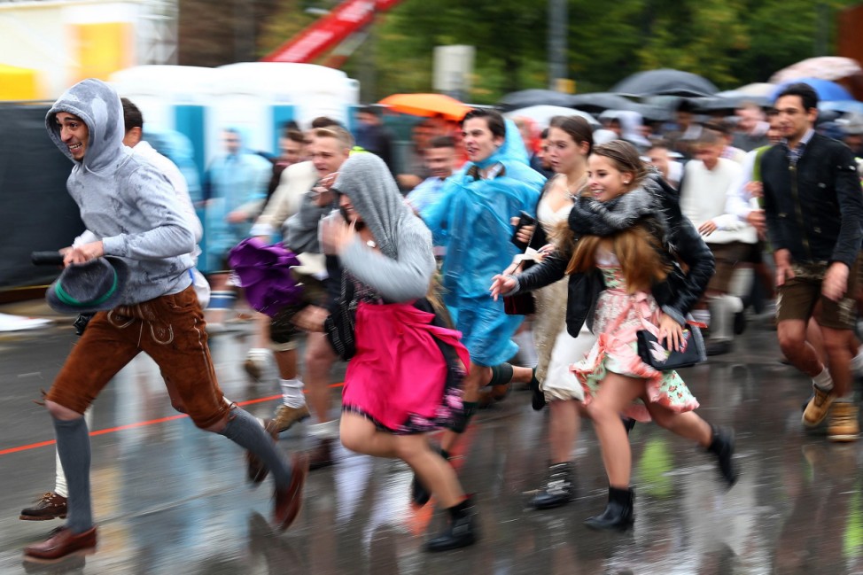 Visitors run to get a spot at the Oktoberfest area after the gates were open at the first day of the 184th Oktoberfest in Munich