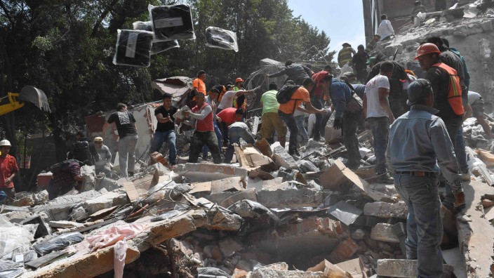 Mexiko-Stadt: Leute räumen in Mexiko-Stadt Trümmer von einem eingestürzten Gebäude, um nach Verschütteten zu suchen.