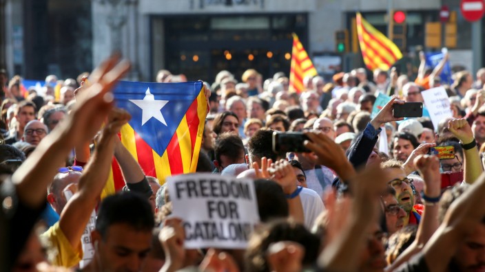 A crowd of protesters gather outside the Catalan region's economy ministry after junior economy minister Josep Maria Jove was arrested by Spanish police during a raid on several government offices, in Barcelona