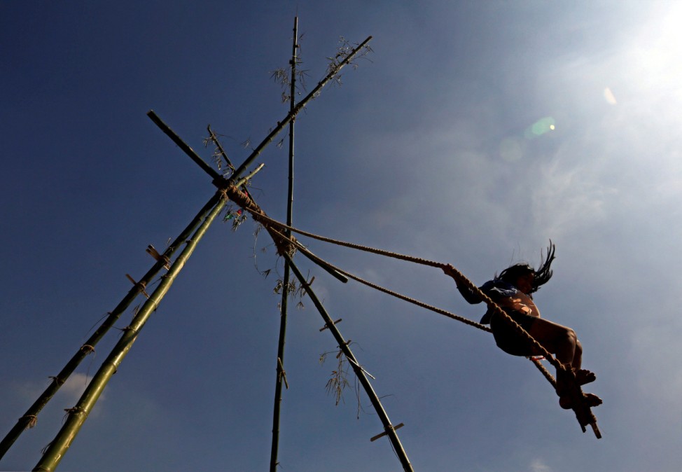 A girl plays on a traditional swing during Dashain, the biggest religious festival for Hindus in Nepal, in Kathmandu
