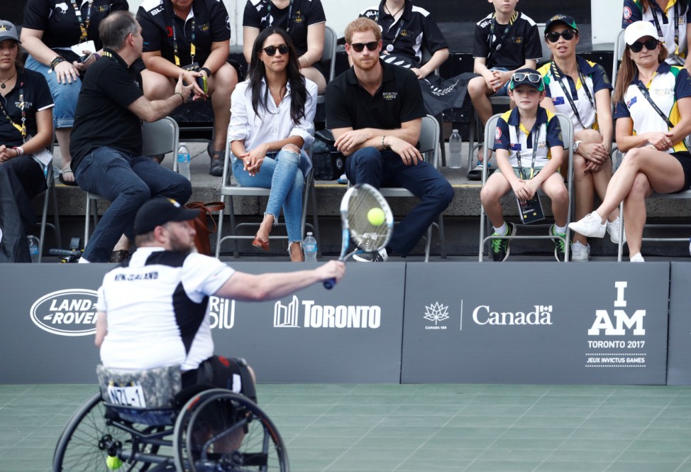 Britain's Prince Harry sits with girlfriend actress Markle to watch a wheelchair tennis event during the Invictus Games in Toronto
