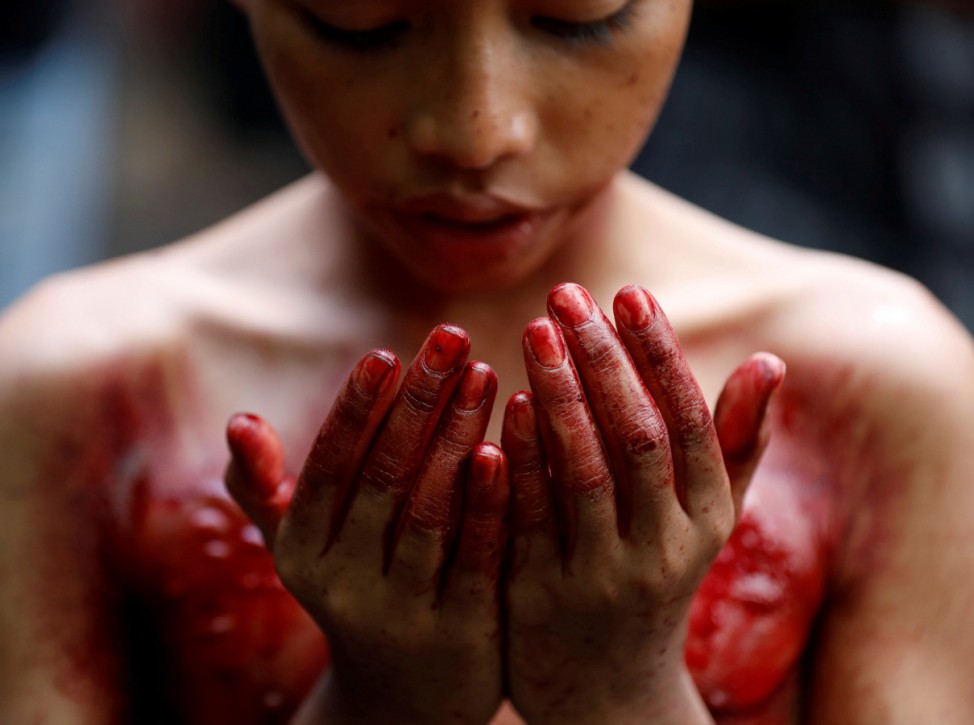 Shi'ite Muslim boy prays after he beat himself at a mosque during Ashura, in Yangon