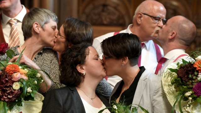 Same-sex couples kiss their partners after get married during a media call at the town hall after the German parliament approved marriage equality in a historic vote this summer, in Hamburg