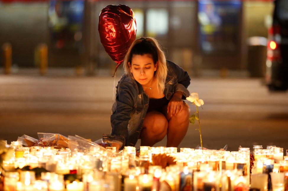 A woman lights candles at a vigil on the Las Vegas strip following a mass shooting at the Route 91 Harvest Country Music Festival in Las Vegas