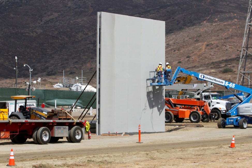 People work in San Diego, California, U.S., at the construction site of prototypes for U.S. President Donald Trump's border wall with Mexico, in this picture taken from the Mexican side of the border in Tijuana, Mexico