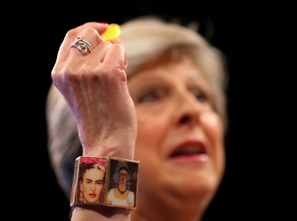 Britain's Prime Minister Theresa May wears a 'Frida Kahlo' bracelet and holds a sweet passed to her as she addresses the Conservative Party conference in Manchester.