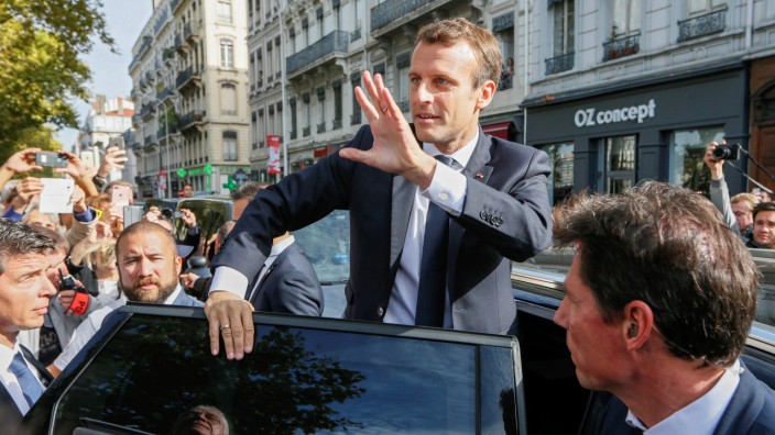 French President Macron waves to supporters during his visit in Lyon