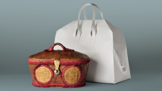 Mode: Minimalismus trifft Pomp: Tasche aus papierähnlichem Vliesstoff von Saskia Diez, davor ein päpstlicher Reisekorb aus dem 17. Jahrhundert.