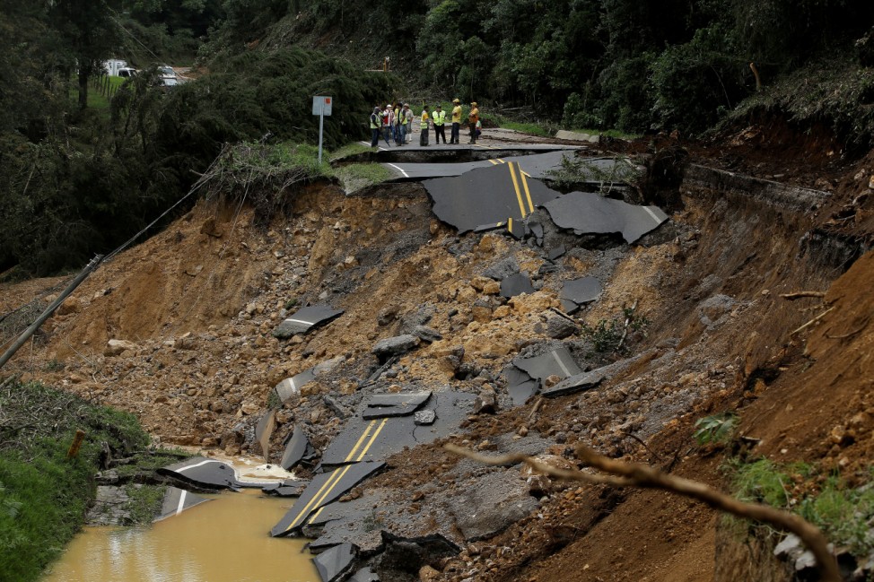 People look at a highway, that connects with the south of the country, collapsed by Storm Nate in Casa Mata, Costa Rica