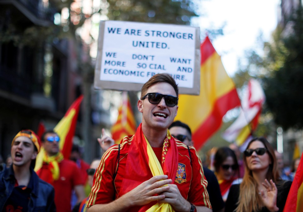 A man walks in front of a placard in English during a pro-union demonstration organised by the Catalan Civil Society organisation in Barcelona