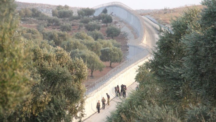 Syrien: Mit der Türkei verbündete Rebellen auf syrischer Seite der drei Meter hohen Mauer, die Ankara im Grenzgebiet hat errichten lassen.