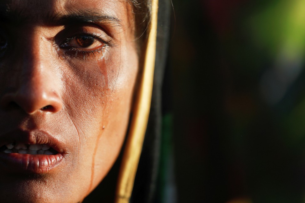 Amina Khatun, a 30 year old Rohingya refugee who fled with her family from Myanmar a day before, cries after she, along with thousands of newly arrived refugees, spent a night by the road between refugee camps near Cox's Bazar