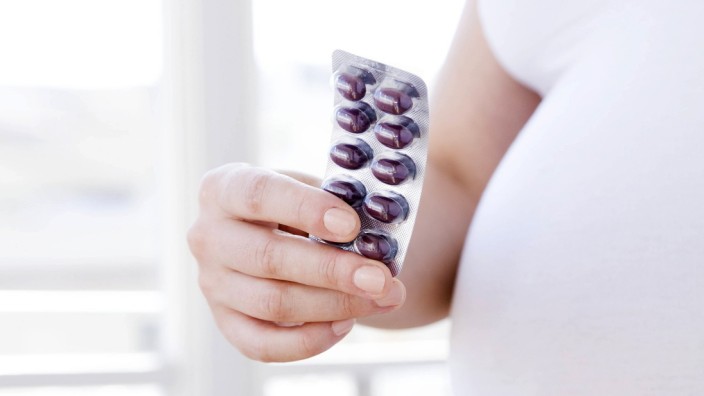 Prenatal vitamins MODEL RELEASED Prenatal vitamins Pregnant woman holding a packet of vitamins Sh