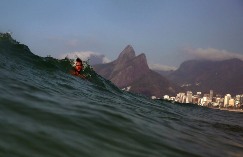 Boy dives into the wave at Ipanema Beach in Rio de Janeiro