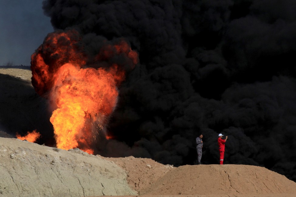 Smoke rises from oil wells, in Dibis area on the outskirts of Kirkuk