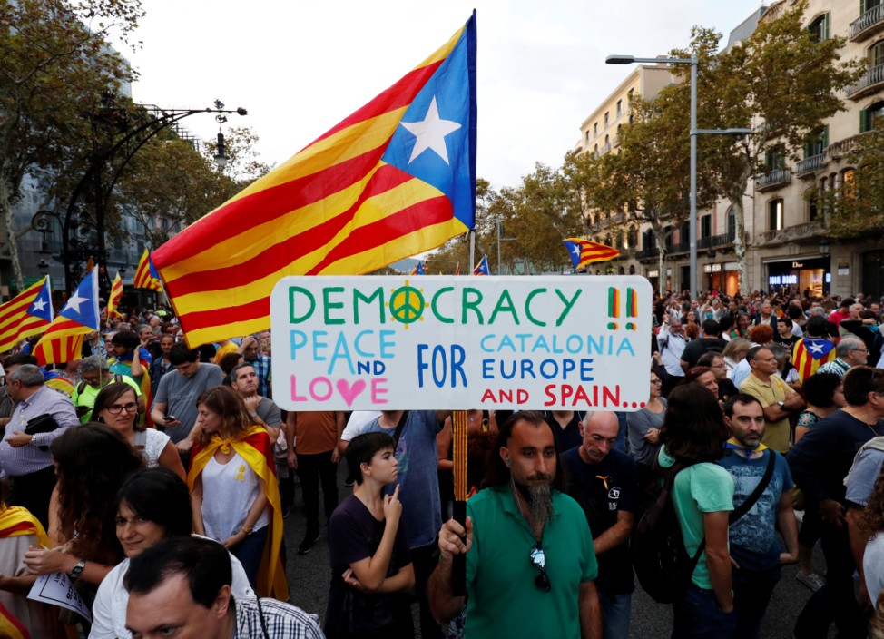 People wave separatist Catalonian flags and placards during a demonstration organised by Catalan pro-independence movements ANC (Catalan National Assembly) and Omnium Cutural, following the imprisonment of their two leaders, in