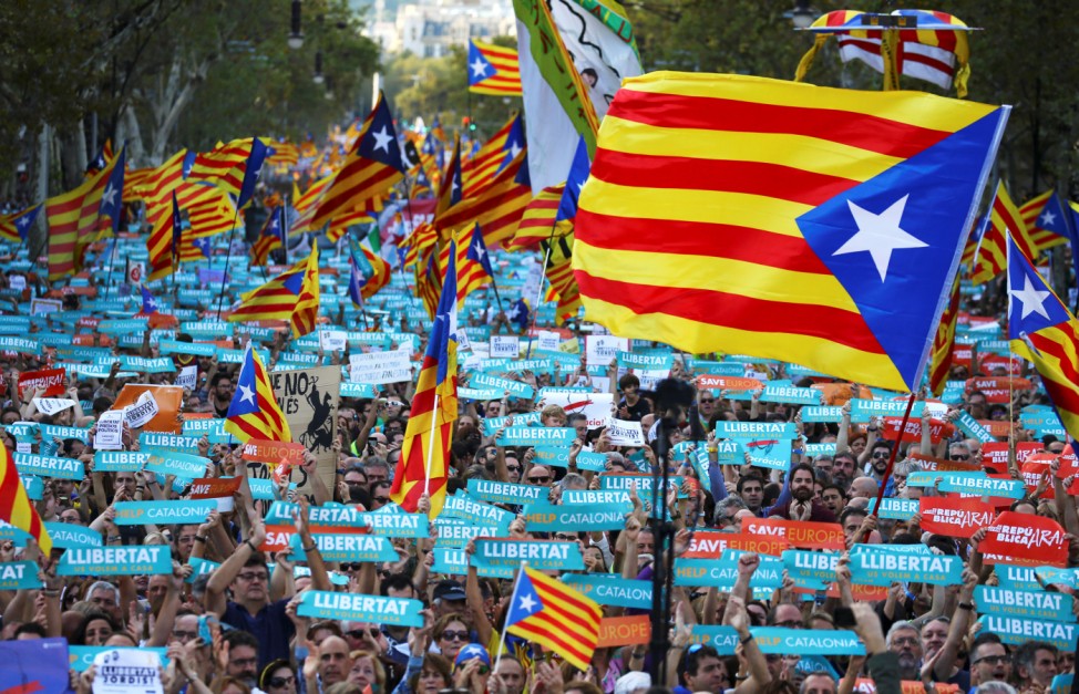 People wave separatisy Catalan flags and placards during a demonstration organised by Catalan pro-independence movements ANC (Catalan National Assembly) and Omnium Cutural, following the imprisonment of their two leaders in Barcelona