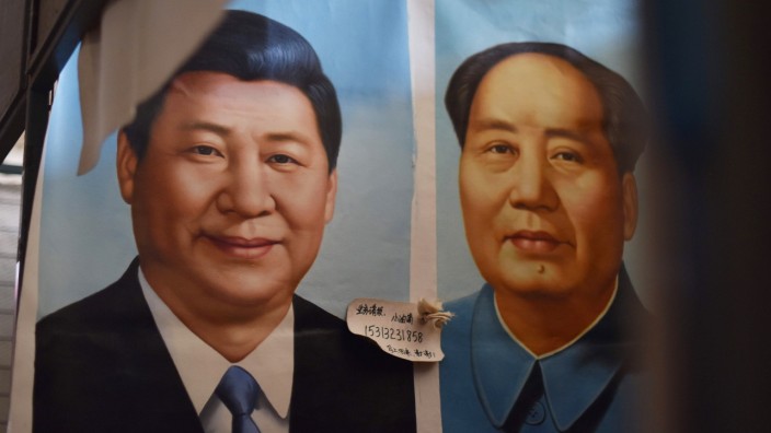 China: Auf einem Markt in Peking hängen die Portraits des derzeitigen chinesischen Staats- und Parteichefs Xi Jinping und Mao Zedongs einträchtig nebeneinander.