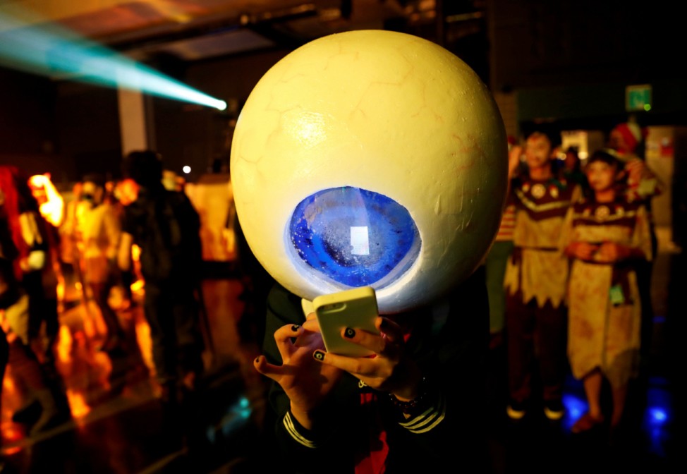 A participant in costume uses a mobile phone at a Halloween event in Kawasaki