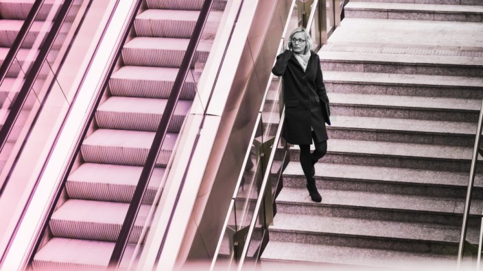Businesswoman on stairs with cell phone model released Symbolfoto PUBLICATIONxINxGERxSUIxAUTxHUNxONL