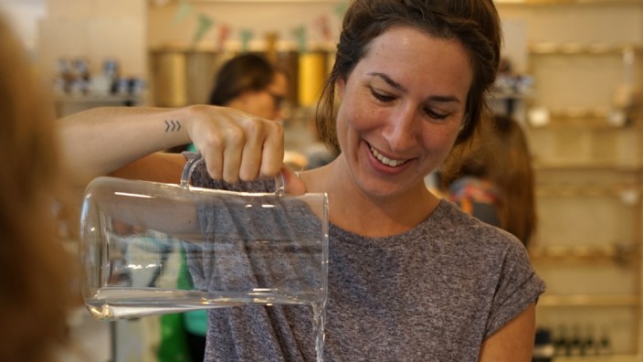 "Refill": Im Ohne-Laden in der Schellingstraße füllt Christine Traub Leitungswasser in eine mitgebrachte Flasche ab, anstatt mehr Plastikmüll zu produzieren.