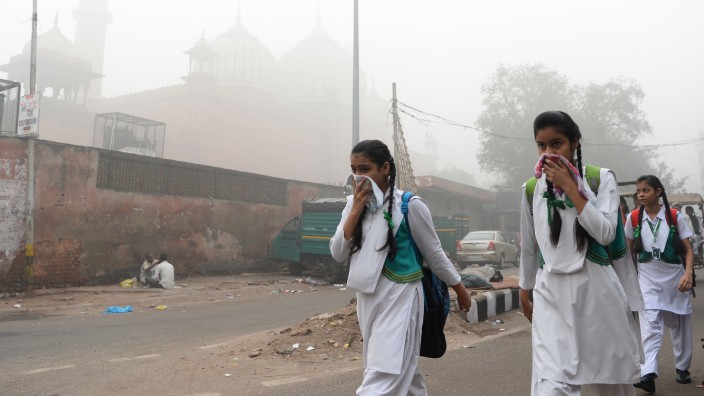 Indien: Schülerinnen in Neu-Delhi auf dem Weg zur Schule: Gegen den Smog soll ein vor den Mund gehaltenes Tuch helfen.