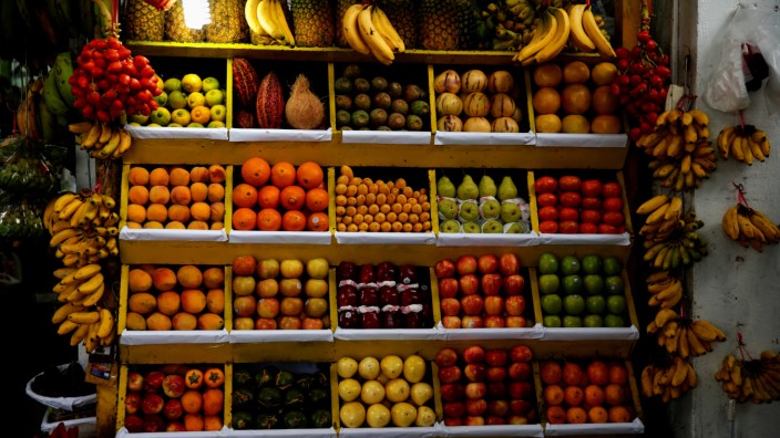 Bananas, apples, mangoes, strawberries, pineapples and other fruits are on display for sale at a market in Lima